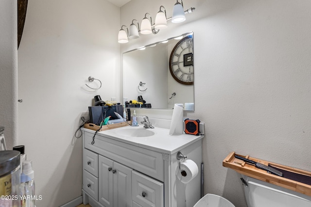 half bath featuring vanity and toilet