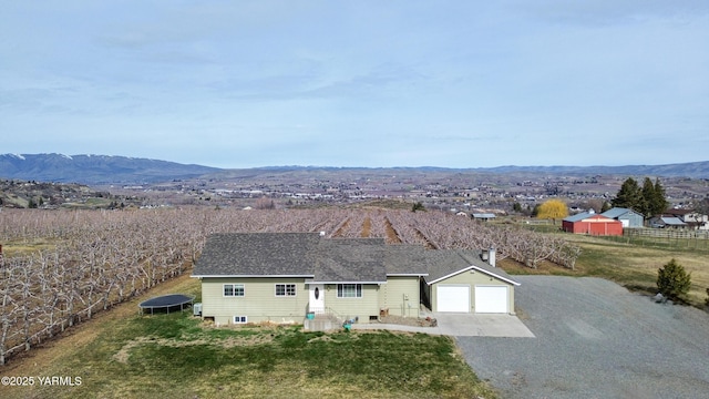 view of front of house featuring a mountain view, driveway, an attached garage, and roof with shingles