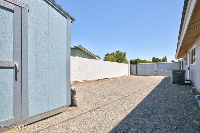 view of yard with a fenced backyard and central AC unit