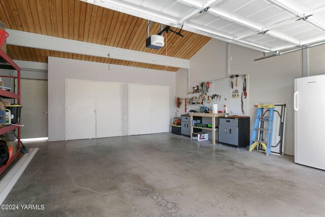 garage with a garage door opener, a workshop area, and freestanding refrigerator