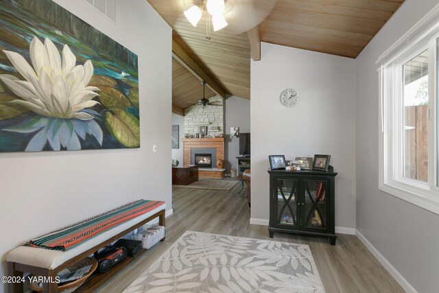 corridor with lofted ceiling with beams, light wood finished floors, and wooden ceiling