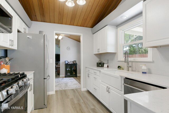 kitchen featuring stainless steel appliances, wooden ceiling, white cabinets, and tasteful backsplash