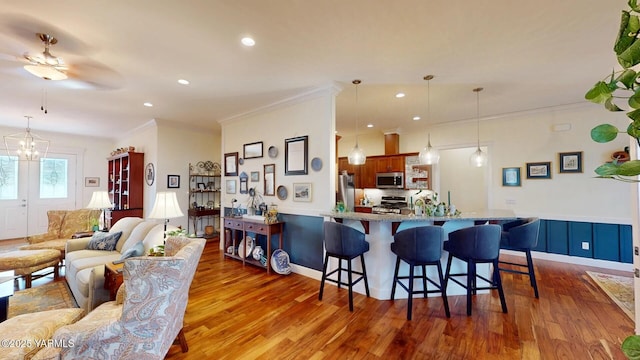 interior space featuring stainless steel microwave, range, a kitchen bar, and wood finished floors