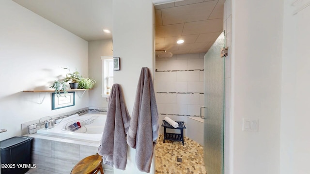 full bathroom featuring a garden tub and a shower stall