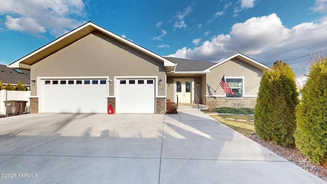 single story home featuring stone siding, an attached garage, and stucco siding