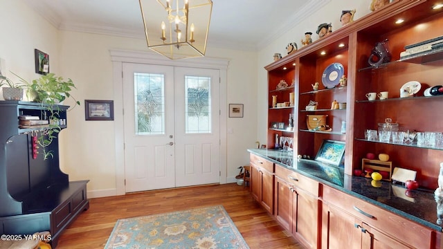 doorway to outside with french doors, ornamental molding, and light wood-type flooring