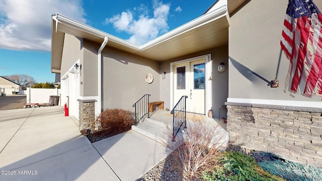 property entrance featuring french doors and stucco siding