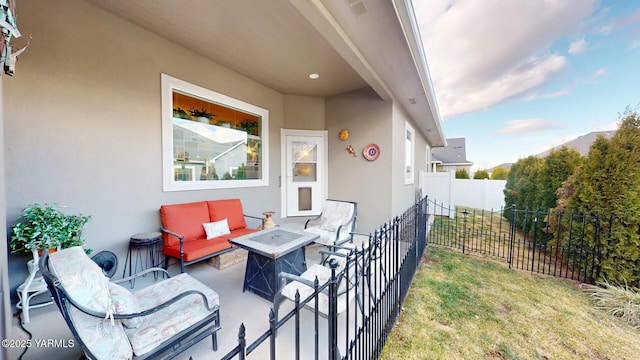 view of patio with an outdoor living space with a fire pit and fence