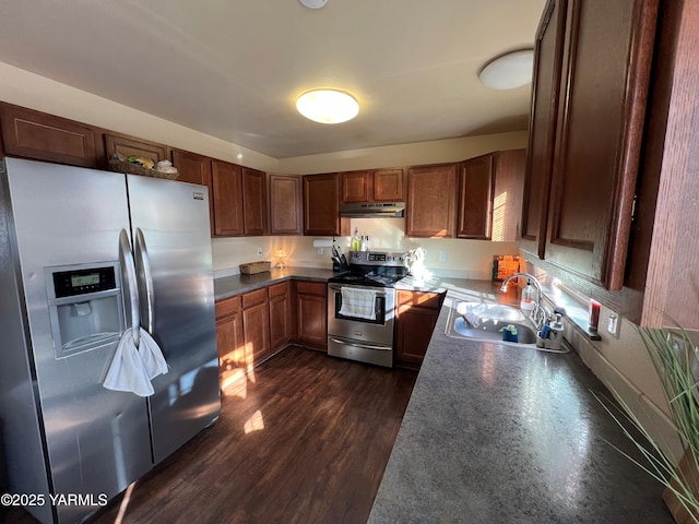 1215 Vineyard Dr, Tieton, WA 98947 - kitchen featuring stainless steel appliances, under cabinet range hood, dark wood finished floors, and brown cabinetry