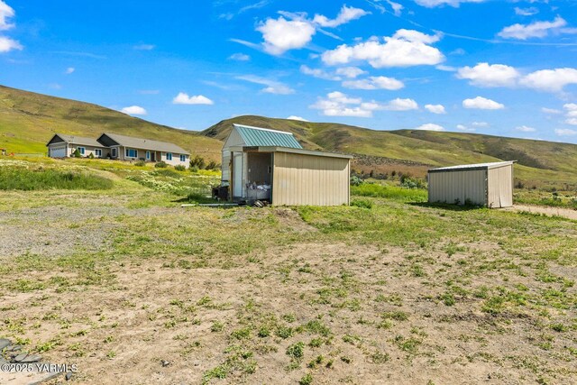 view of yard with a shed, a mountain view, and an outdoor structure