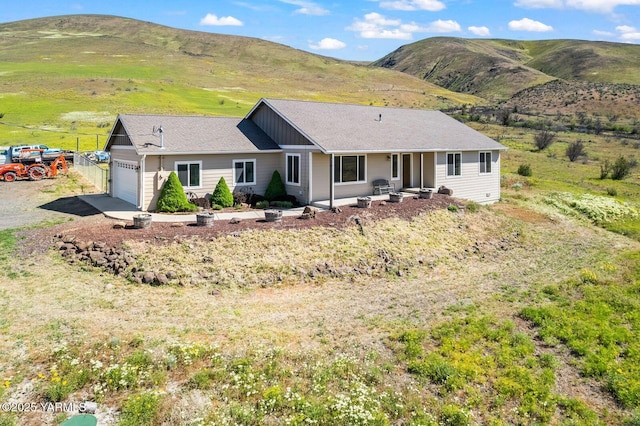single story home with an attached garage and a mountain view