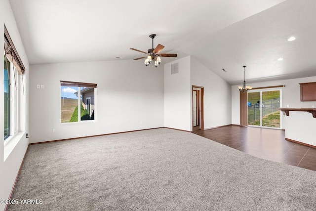 unfurnished living room with vaulted ceiling, dark colored carpet, a chandelier, a ceiling fan, and baseboards