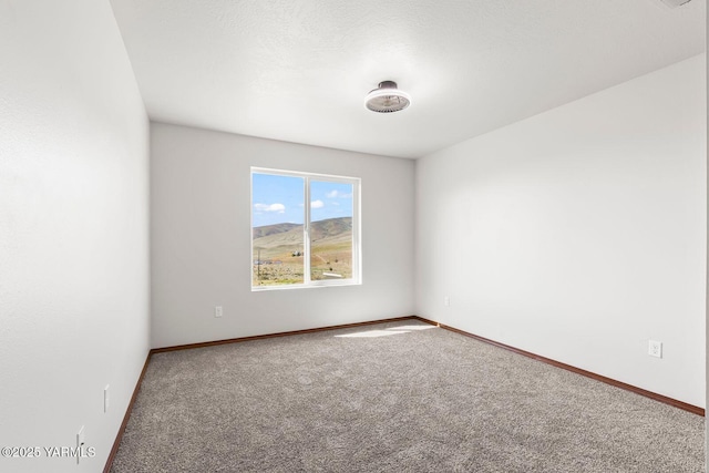 carpeted spare room with baseboards