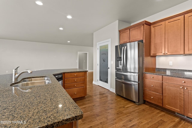 1008 S 91st Ave, Yakima, WA 98908 - kitchen with stainless steel fridge, a sink, wood finished floors, brown cabinets, and dark stone counters