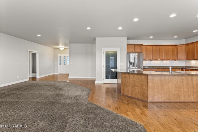 1008 S 91st Ave, Yakima, WA 98908 - kitchen with stainless steel fridge, a sink, light wood-style floors, recessed lighting, and dark stone countertops