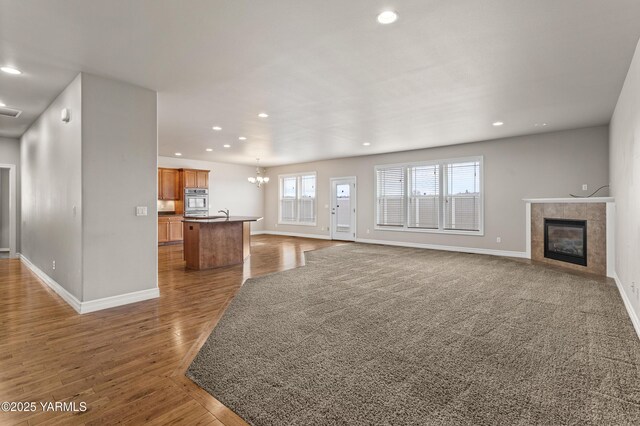 1008 S 91st Ave, Yakima, WA 98908 - unfurnished living room with baseboards, a fireplace, a chandelier, recessed lighting, and wood finished floors