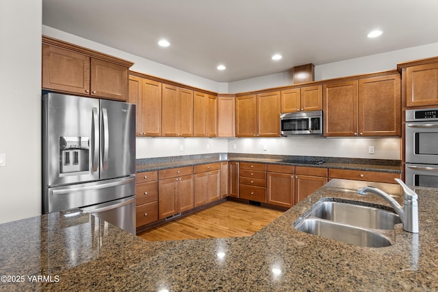 1008 S 91st Ave, Yakima, WA 98908 - kitchen with stainless steel appliances, a sink, brown cabinets, dark stone counters, and recessed lighting