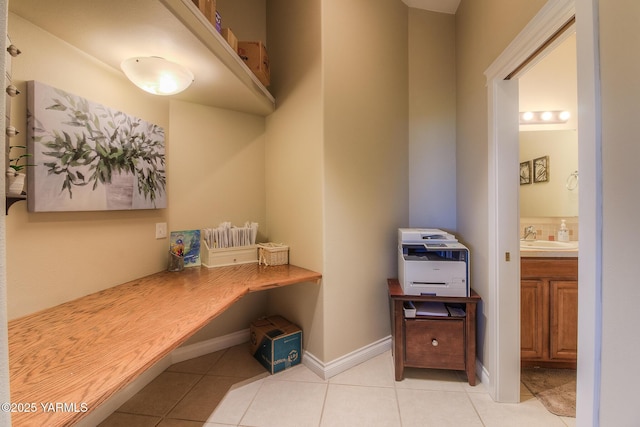 mudroom featuring light tile patterned floors, baseboards, and a sink