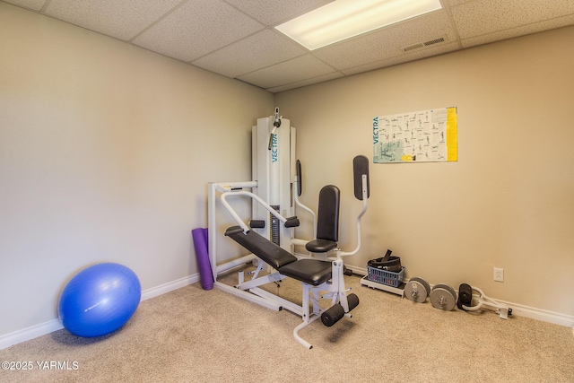 workout room featuring carpet floors, a paneled ceiling, visible vents, and baseboards