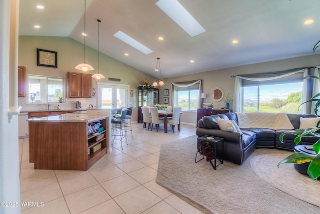 living room with a skylight, light tile patterned flooring, and recessed lighting