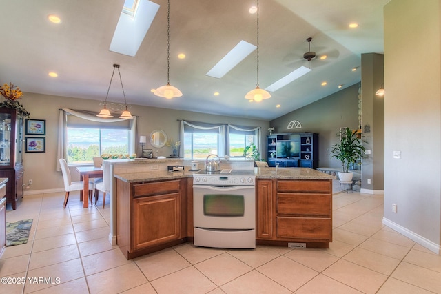 kitchen featuring white range with electric stovetop, pendant lighting, a skylight, brown cabinetry, and a healthy amount of sunlight