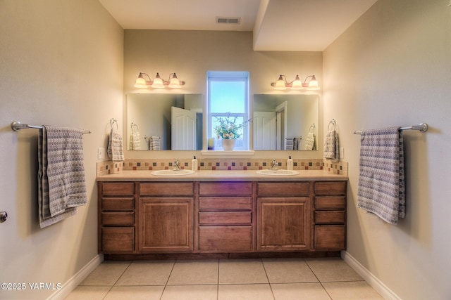 bathroom featuring tasteful backsplash, a sink, and visible vents