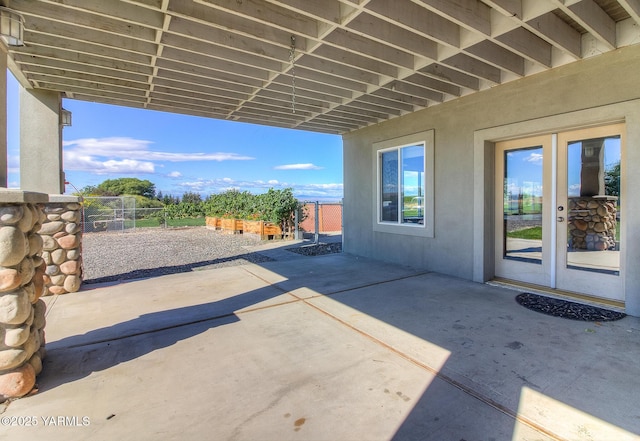 view of patio featuring french doors and fence