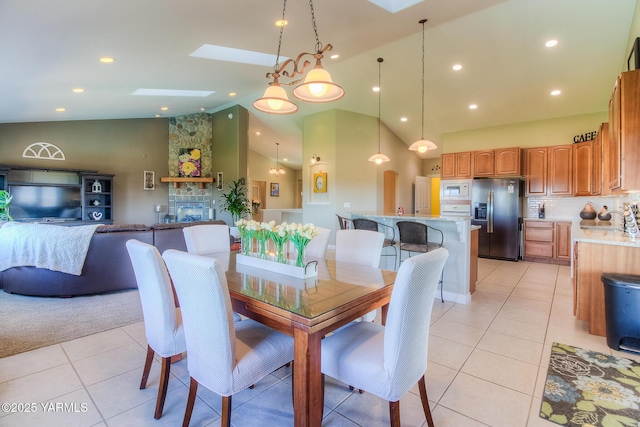 dining area with light tile patterned floors, high vaulted ceiling, a skylight, and recessed lighting