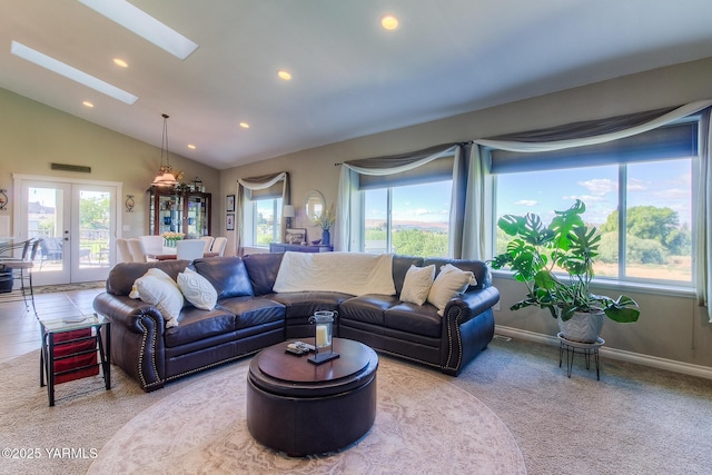 living area with a wealth of natural light, french doors, vaulted ceiling with skylight, and recessed lighting