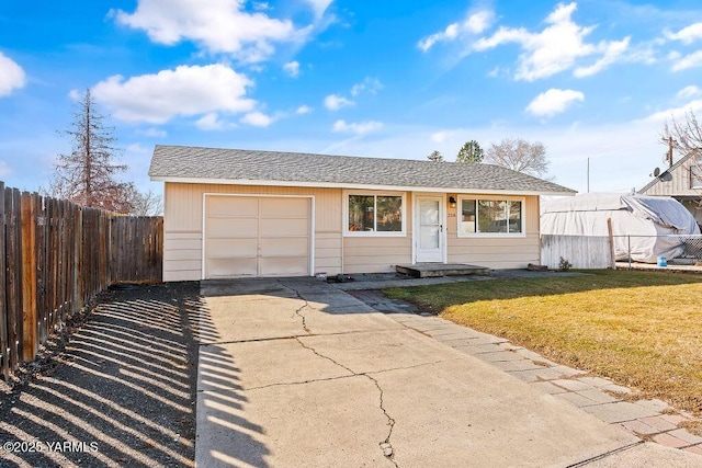 ranch-style house featuring roof with shingles, concrete driveway, an attached garage, a front yard, and fence