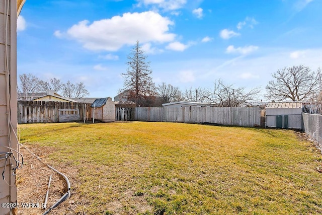 view of yard with an outbuilding, a fenced backyard, and a storage shed