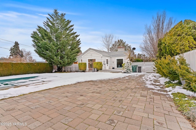 view of front of house featuring a gate, fence, and a chimney