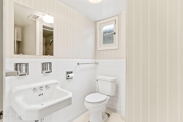 bathroom with visible vents, wainscoting, a sink, and toilet