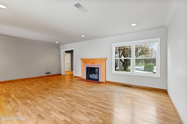 unfurnished living room with light wood-style flooring and visible vents