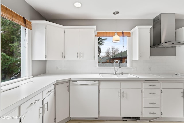 kitchen with white cabinets, wall chimney range hood, white appliances, and a sink