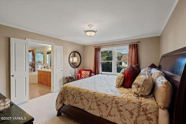 bedroom with ensuite bathroom, ornamental molding, a sink, and light colored carpet