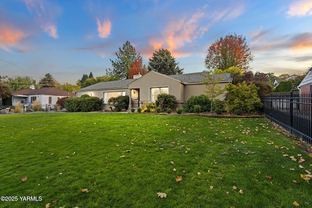 ranch-style house featuring a front lawn, fence private yard, and stucco siding