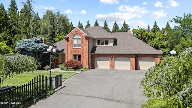 view of front of house featuring fence, roof with shingles, an attached garage, a front lawn, and brick siding