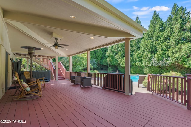 wooden terrace featuring stairs, an outdoor pool, a hot tub, and ceiling fan