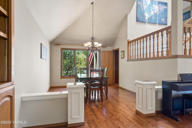 dining space featuring lofted ceiling, an inviting chandelier, and wood finished floors