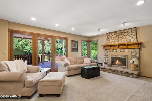 living area featuring recessed lighting, french doors, carpet floors, and a stone fireplace