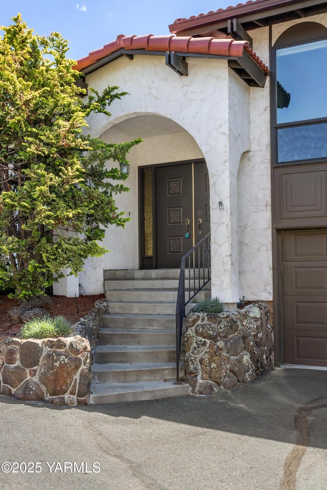 24 Crest Cir, Yakima, WA 98908 - entrance to property with a tiled roof, stone siding, a garage, and stucco siding