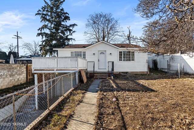 back of house featuring a fenced backyard and a deck