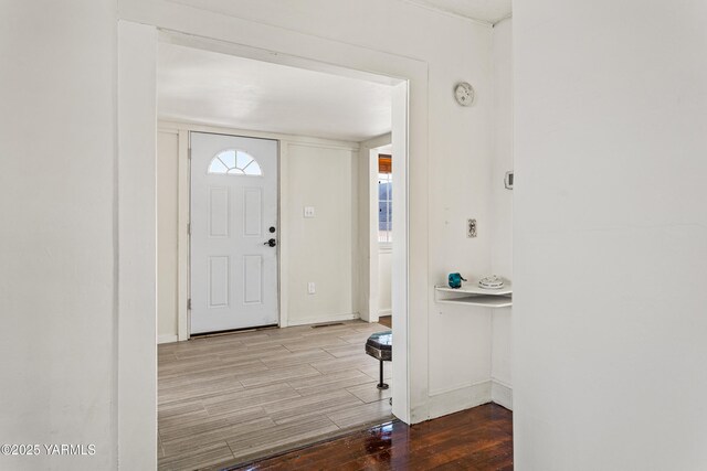 entrance foyer with baseboards and wood finished floors