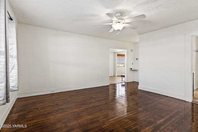 empty room featuring dark wood-style floors, ceiling fan, baseboards, and a textured ceiling