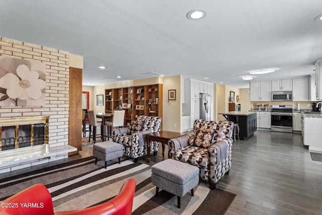 5910 W Lincoln Ave Unit 36, Yakima, WA 98908 - living area with dark wood-style flooring, a fireplace, and recessed lighting