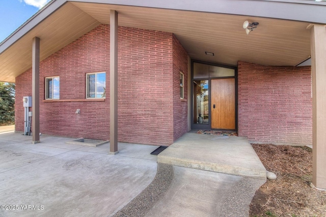 doorway to property with brick siding