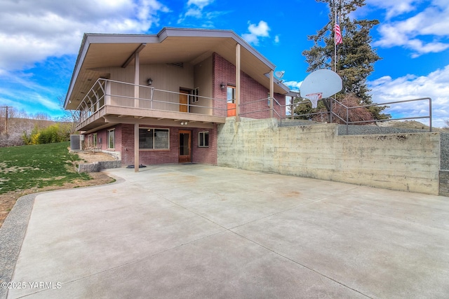 back of property featuring a yard and brick siding