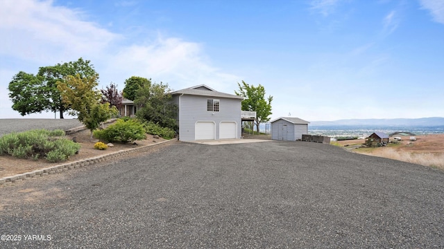 40 Vista Verde Dr, Yakima, WA 98901 - view of front of home featuring an attached garage, gravel driveway, an outdoor structure, and a mountain view