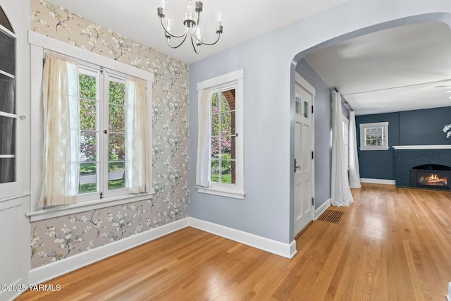 interior space featuring baseboards, plenty of natural light, and wood finished floors